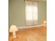 Bedroom featuring light green walls, hardwood floors, and natural light from a large window at 223 Windsor St # 3A, Lakeland, FL 33803