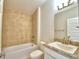 Bathroom with beige tile, a bathtub, toilet and vanity at 237 Piave St, Haines City, FL 33844