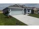 Single-story home with two-car garage, light-blue exterior paint, and driveway at 237 Piave St, Haines City, FL 33844