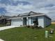 Single-story home with light blue exterior paint, two-car garage and a well manicured lawn at 237 Piave St, Haines City, FL 33844