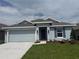 Charming single-story home with a two-car garage, blue shutters, and well-maintained landscaping at 237 Piave St, Haines City, FL 33844