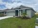 Lovely one-story home with lush lawn, a two-car garage, and tidy landscaping around the entrance at 245 Piave St, Haines City, FL 33844