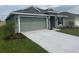 Inviting single-story home featuring a well-kept lawn, two-car garage, and sidewalk to front door at 245 Piave St, Haines City, FL 33844