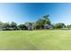 A well-manicured golf course surrounding a clubhouse exterior with palm trees at 3273 Pebble Bend Dr, Lakeland, FL 33810