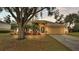 Tan house with arched entryway, two-car garage, and palm trees at 3445 Sleepy Hill Oaks St, Lakeland, FL 33810