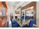 Bright dining room features a glass-top table and blue chairs, offering a view of the kitchen at 4009 Oakley Way, Lakeland, FL 33813