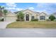 Tan house with a welcoming front porch and lush green grass at 4009 Oakley Way, Lakeland, FL 33813