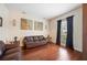 Living room with hardwood floors, a brown leather couch, and large windows at 4009 Oakley Way, Lakeland, FL 33813