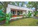 Inviting front porch with wooden decking, ceiling fan, and lush landscaping at 401 E Belmar St, Lakeland, FL 33803