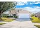 Two-story house with a white garage door and landscaped lawn at 4048 Windchime Ln, Lakeland, FL 33811