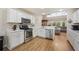 Open kitchen with white cabinets, stainless steel appliances, and hardwood floors at 4048 Windchime Ln, Lakeland, FL 33811