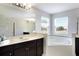 Elegant bathroom with a soaking tub, double vanity, and mosaic tile at 4179 Oaktree Dr, Davenport, FL 33837