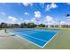 Two blue tennis courts with surrounding fencing at 4308 Whistlewood Cir, Lakeland, FL 33811