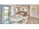 Dining area with white table and chairs, sliding doors to backyard at 442 Jacks Way, Davenport, FL 33837