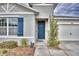 Modern teal front door with gray siding and blue shutters at 442 Jacks Way, Davenport, FL 33837