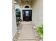 Inviting home entryway featuring a decorative front door, stone pathway, and beautiful potted plants at 4435 Fairway Oaks Dr, Mulberry, FL 33860