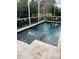 Relaxing screened pool with fountain and stone deck at 4435 Fairway Oaks Dr, Mulberry, FL 33860