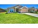 Two-car garage and neatly landscaped lawn in front of a tan house at 527 Tanaro Ln, Haines City, FL 33844