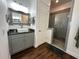 Modern bathroom with gray vanity, frameless shower, and decorative mirror at 593 Meandering Way, Polk City, FL 33868