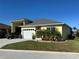 Bright yellow house exterior with palm trees and a paved driveway at 593 Meandering Way, Polk City, FL 33868