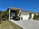 House exterior showcasing RV garage, paved driveway, and landscaping at 593 Meandering Way, Polk City, FL 33868