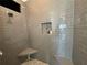 Modern shower with gray tile, built-in seat, and decorative niche at 593 Meandering Way, Polk City, FL 33868