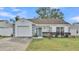 White one-story house with gray accents, attached garage, and well-maintained lawn at 6111 Morningview Dr, Lakeland, FL 33813