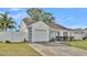 Front view of a single-story house with a white exterior, gray accents, and a spacious lawn at 6111 Morningview Dr, Lakeland, FL 33813