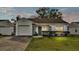 Single-story house with white exterior, gray accents, and a lawn at 6111 Morningview Dr, Lakeland, FL 33813