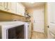 Well-equipped laundry room with washer, dryer and overhead cabinets at 6358 Alamanda Hills Dr, Lakeland, FL 33813