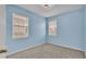 Light blue walls and carpeted bedroom with two windows at 649 Grasslands Village Cir, Lakeland, FL 33803