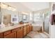 Large bathroom featuring double sinks, a corner tub, and a shower at 6550 Evergreen Park Dr, Lakeland, FL 33813