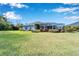 House backyard with lush green grass and a screened enclosure at 7068 Island Lake Ln, Lakeland, FL 33813