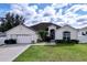 House exterior featuring a two-car garage and well-maintained lawn at 8 Sawfish Ln, Kissimmee, FL 34759