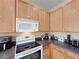 Bright kitchen featuring oak cabinets and a modern stove top at 8 Sawfish Ln, Kissimmee, FL 34759