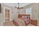 Cozy bedroom with a queen-size bed, wood furniture, and ceiling fan at 875 Hanover Way, Lakeland, FL 33813