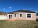 Back of house with patio and grassy backyard at 1038 Suffragette Cir, Haines City, FL 33844