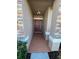 Covered entryway with a terracotta-colored floor and a brown door at 1038 Suffragette Cir, Haines City, FL 33844