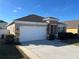 House exterior showcasing a two-car garage and stone accents at 1038 Suffragette Cir, Haines City, FL 33844