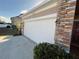 White two-car garage with stone accents and exterior lights at 1038 Suffragette Cir, Haines City, FL 33844