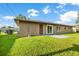 Home's backyard with green lawn, fenced area, and sliding glass doors offering seamless indoor-outdoor living at 123 Padgett N Pl, Lakeland, FL 33809