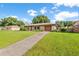 Quaint home with an attached garage, long driveway, and a meticulously manicured green lawn at 123 Padgett N Pl, Lakeland, FL 33809