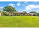 Home with a spacious front yard, complemented by mature trees, an outbuilding, and a long driveway at 123 Padgett N Pl, Lakeland, FL 33809