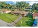 Aerial view of home featuring landscaping, driveway, and a welcoming front facade at 123 Padgett N Pl, Lakeland, FL 33809