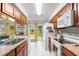 Kitchen area with wood cabinets, a sink, and adjacent backyard access at 123 Padgett N Pl, Lakeland, FL 33809