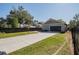 Detached garage with a gray exterior, black door, and a long driveway at 127 W Belmar St, Lakeland, FL 33803