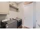 Well-equipped laundry room featuring a gray washer and dryer, plus a storage shelf and charming decor at 127 W Belmar St, Lakeland, FL 33803