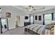 Bright bedroom with a ceiling fan, gray carpet, television, ensuite bathroom and blackout curtains at 1336 Melrose St, Lake Alfred, FL 33850