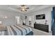 Bright bedroom with a ceiling fan, gray carpet, television, ensuite bathroom and view into the living room at 1336 Melrose St, Lake Alfred, FL 33850