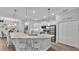 Bright kitchen island with seating, pendant lights, white cabinets and views to the dining area at 1336 Melrose St, Lake Alfred, FL 33850